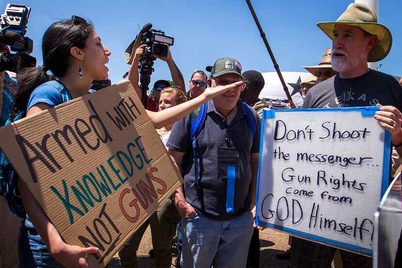 Dueling groups demonstrated outside Dallas City Hall during the NRA Annual Meeting &...