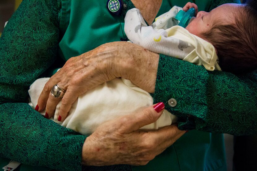 Volunteer Beverley Denman holds Anthony Gonzalez at Texas Health Presbyterian Hospital in...