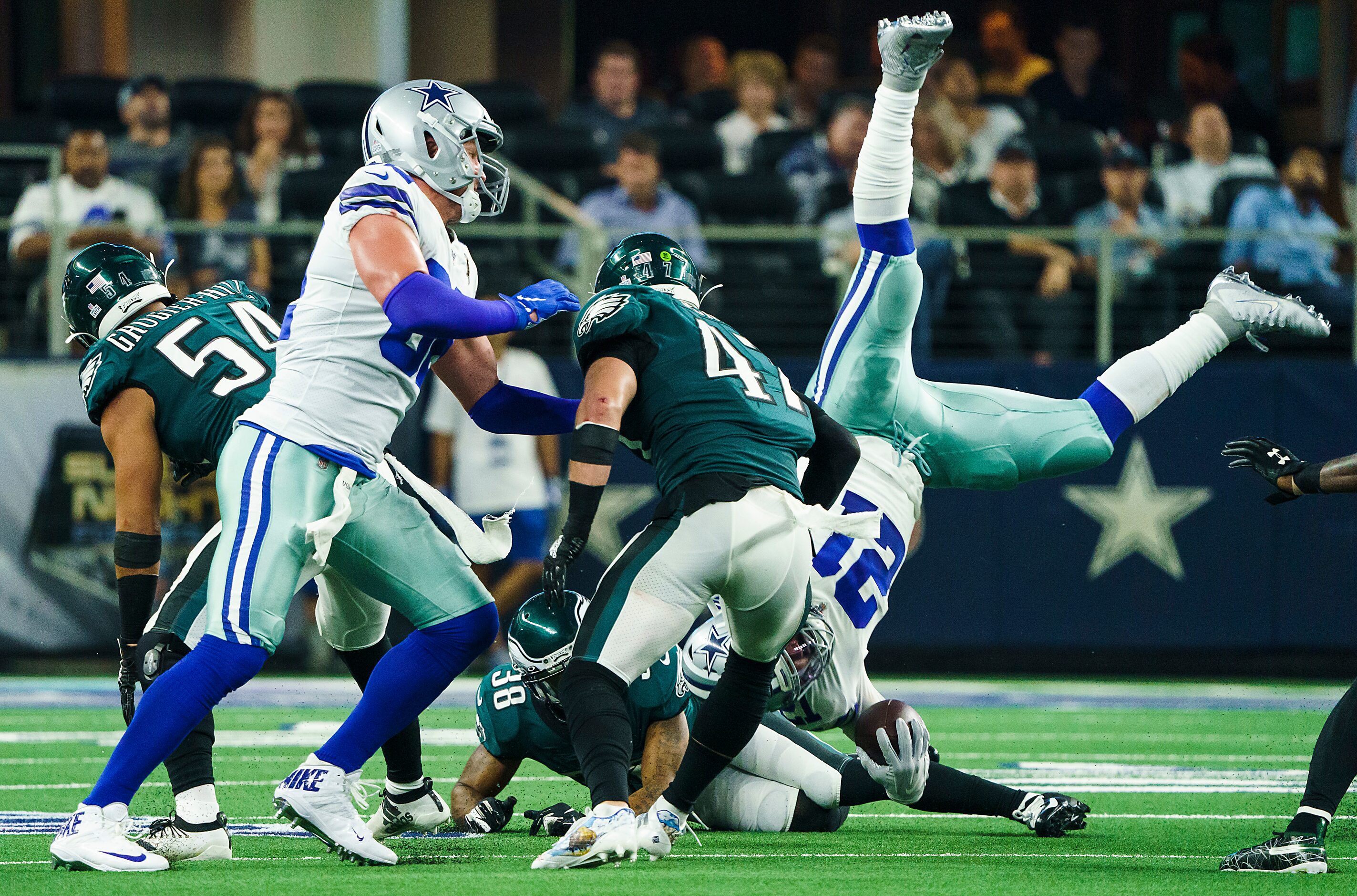 Dallas Cowboys running back Ezekiel Elliott (21) is upended by Philadelphia Eagles defensive...