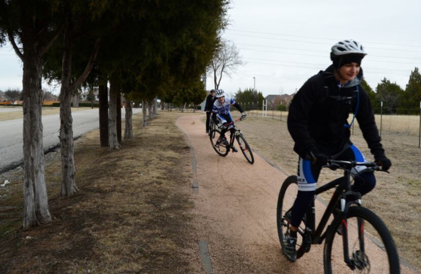 Charlie Satterthwaite pedals along the path at Richardson's Breckinridge Park as one of his...