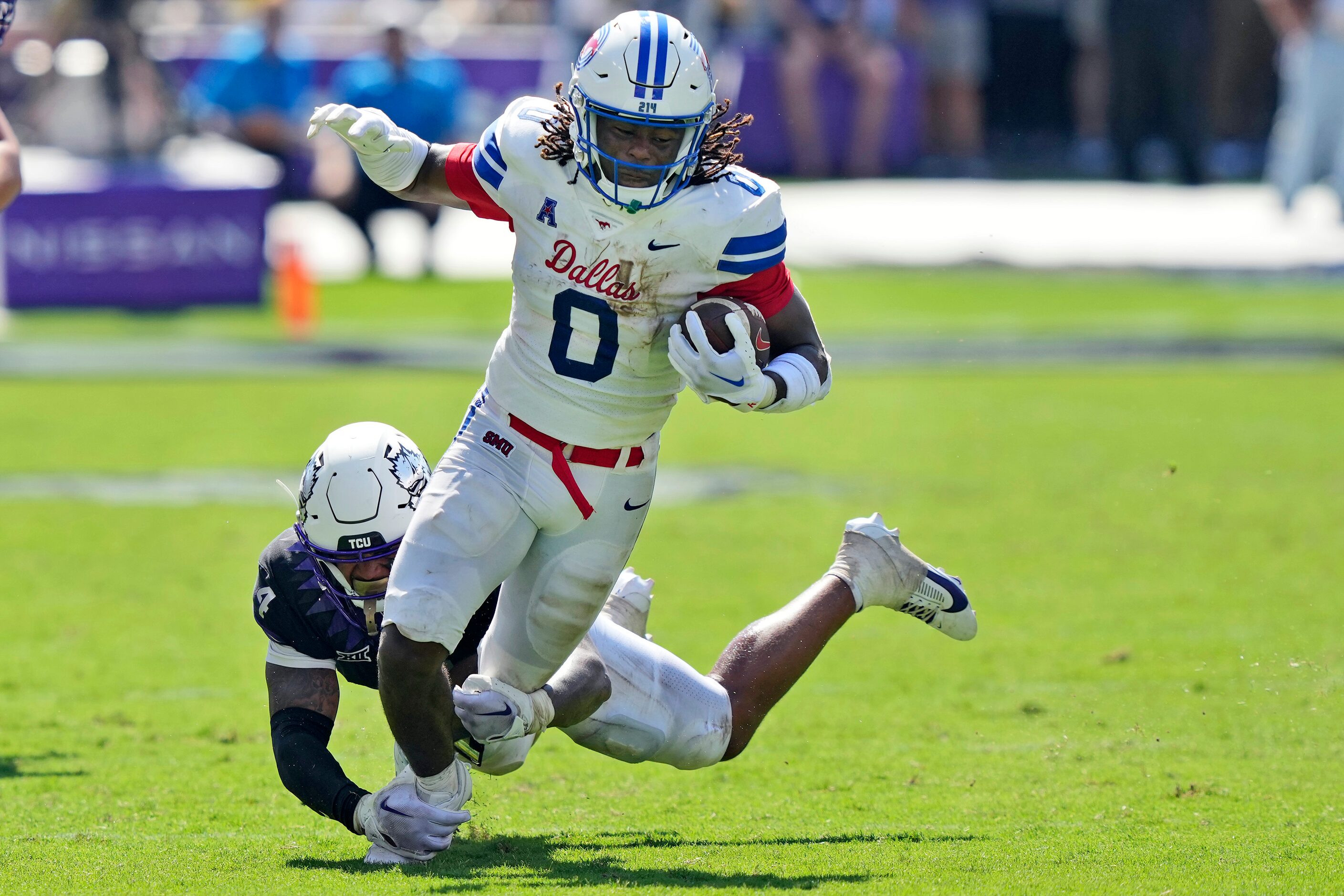 SMU running back Camar Wheaton (0) carries the ball as TCU linebacker Namdi Obiazor (4)...