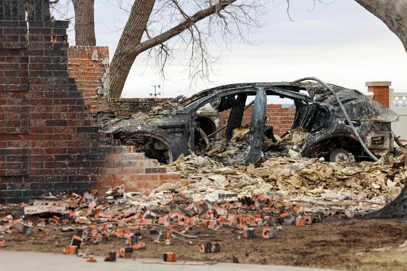 A car destroyed by the Smokehouse Creek Fire is seen through the remains of a house,...