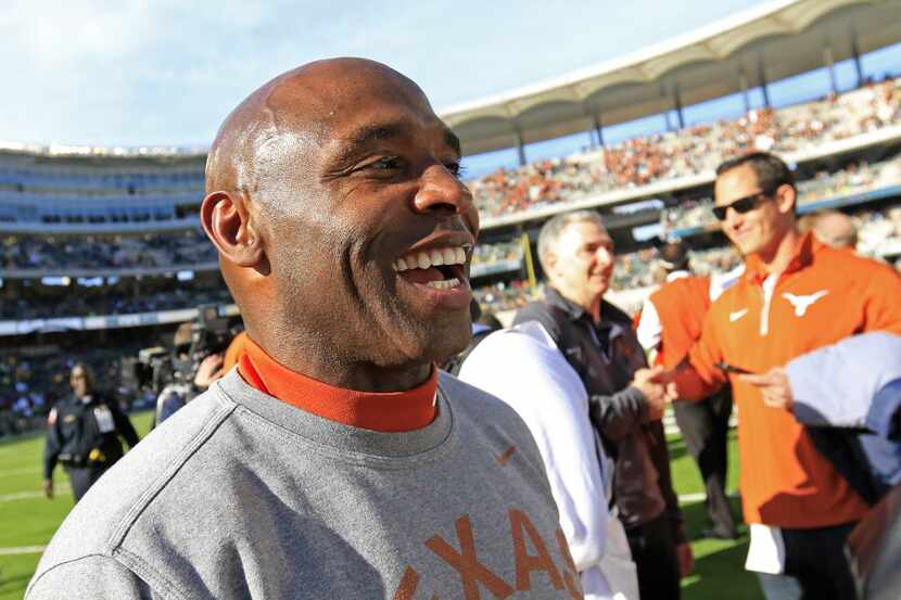 Texas head coach Charlie Strong smiles as he leaves the field after a 23-17 win over Baylor...