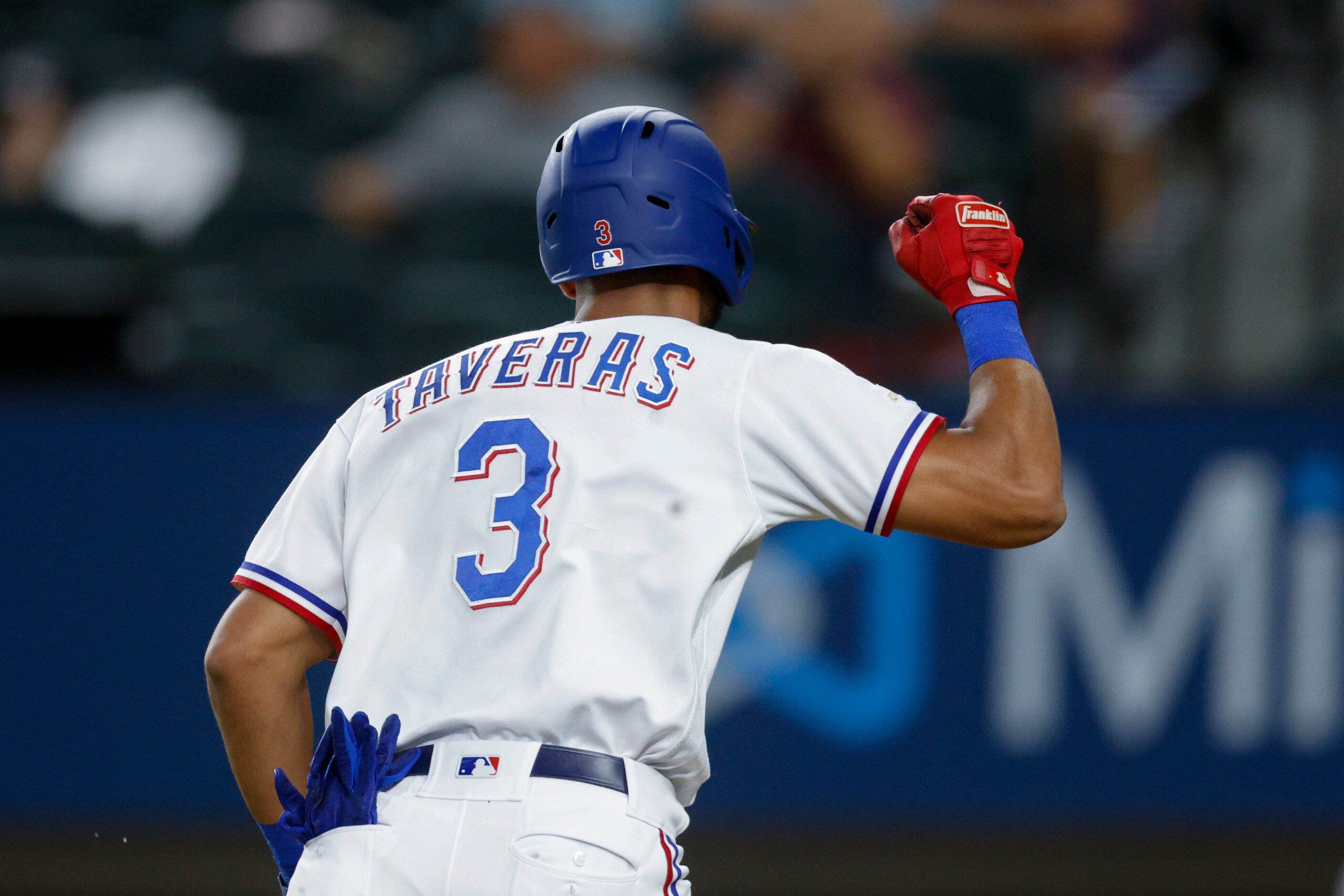 Texas Rangers center fielder Leody Taveras (3) pumps his fist as he scores a run on a single...