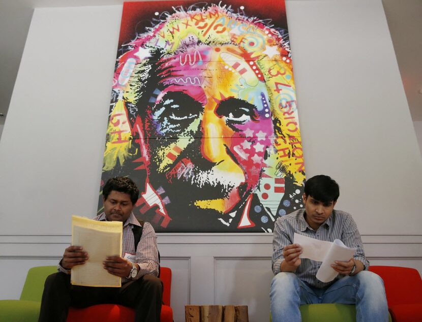 Sanil Talauiker (left) and Jeshwanth Challagundla, both of Arlington, read over papers...