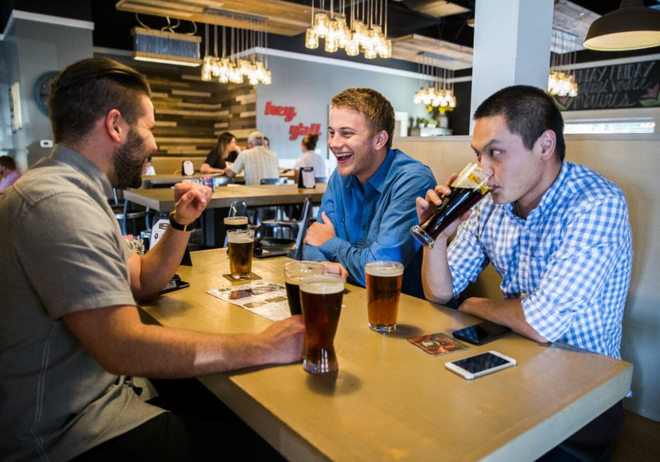 From left, Joseph Kabrane, Sam Alspach and Alex Ng enjoy beers and conversation on...