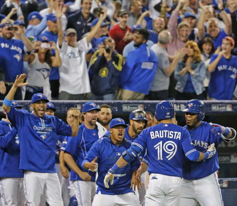 Teammates greet Toronto Blue Jays right fielder Jose Bautista (19) after his three run homer...