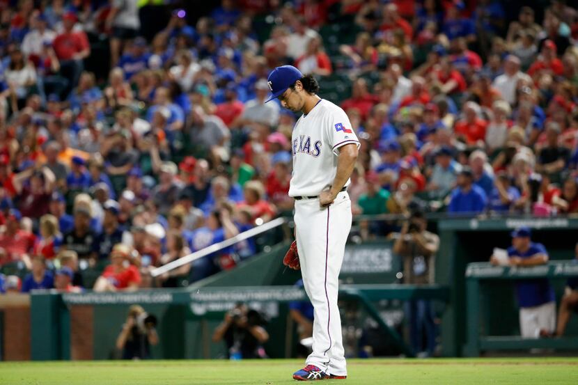Rangers starting pitcher Yu Darvish hangs his head after giving up a 3-run home run to...