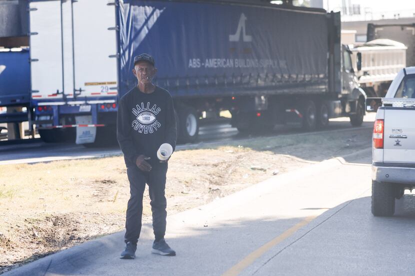 A man stands in a traffic lane on the ramp entering the I-30 in Dallas in October 2022...