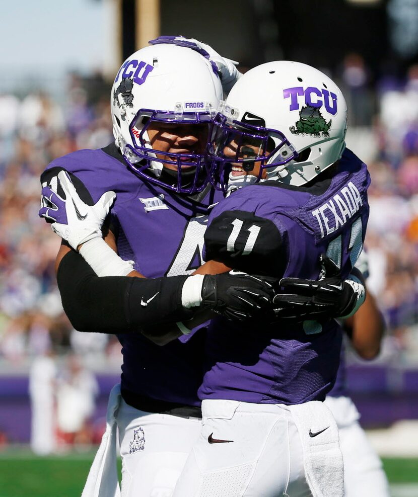 TCU cornerback Ranthony Texada (11) celebrates with teammates after he intercepted the ball...