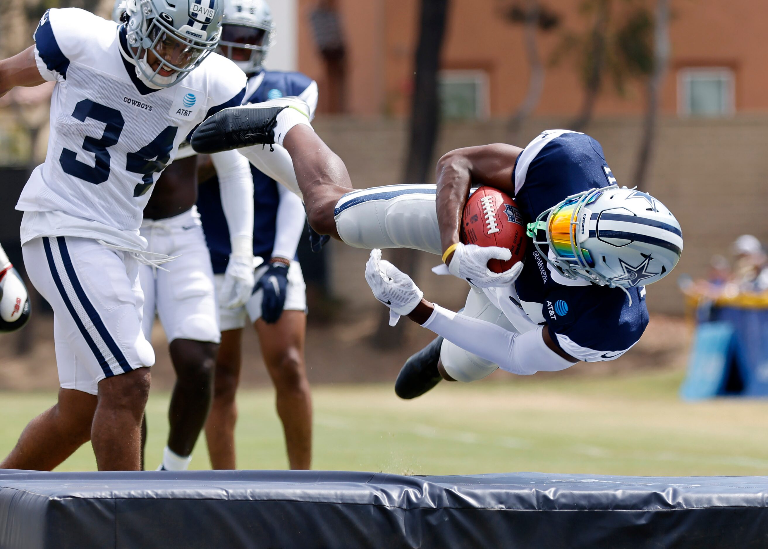 Dallas Cowboys safety Israel Mukuamu (24) is flipped as running back Malik Davis (34) tried...