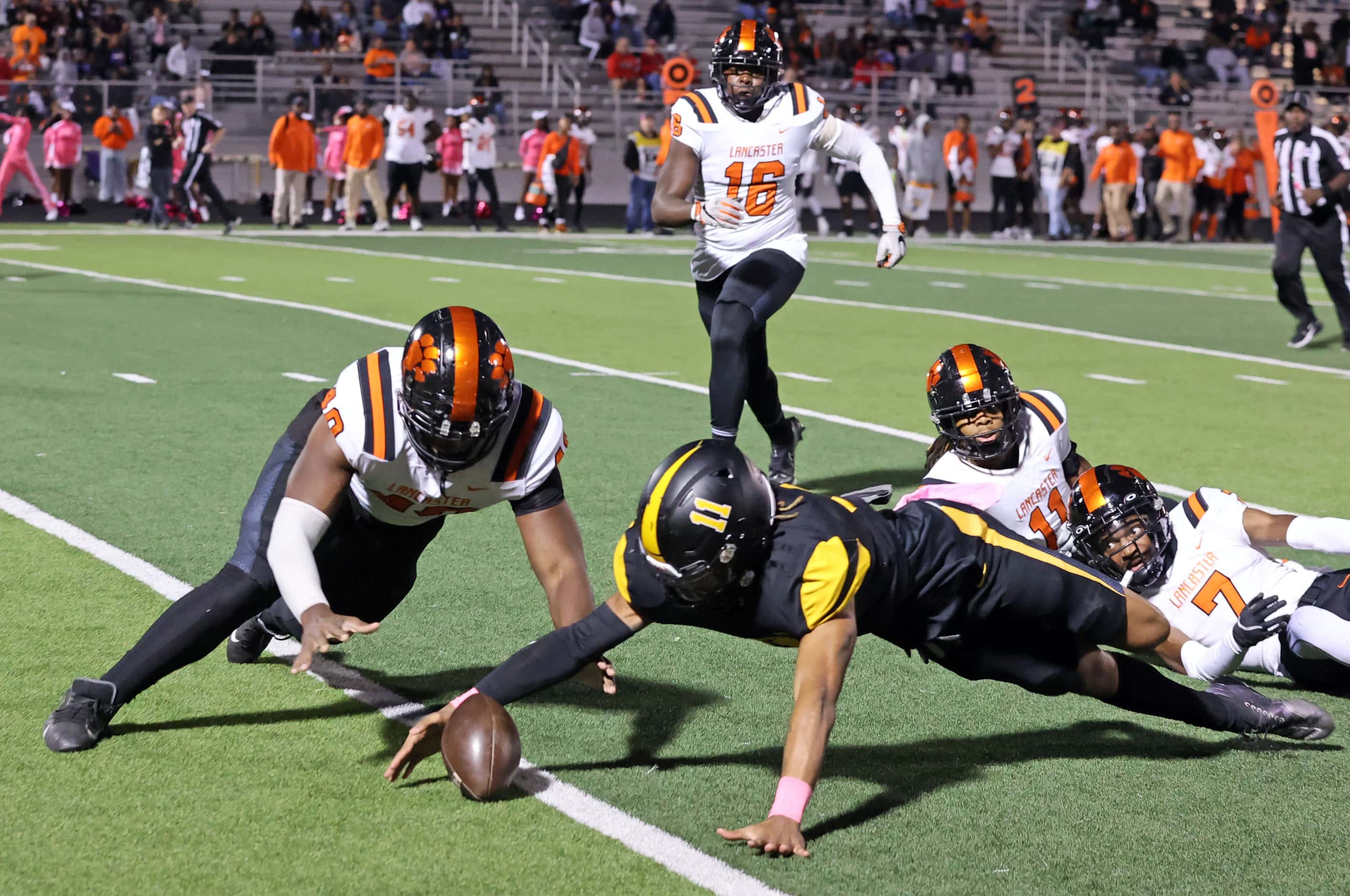 Forney high’s Orin Gee (11) fumbles the football, as Lancaster’s Jakobe Williams (40) tries...