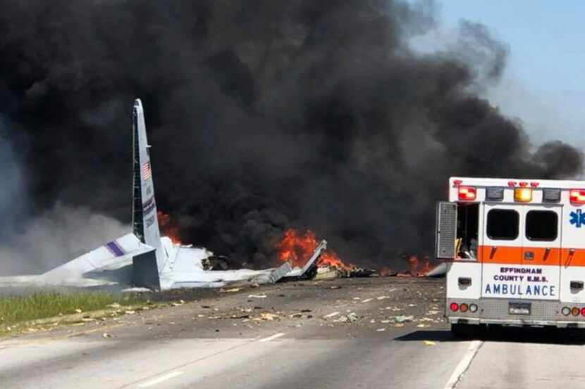 FAn ambulance sits near the burning wreckage of an Air National Guard C-130 cargo plane...