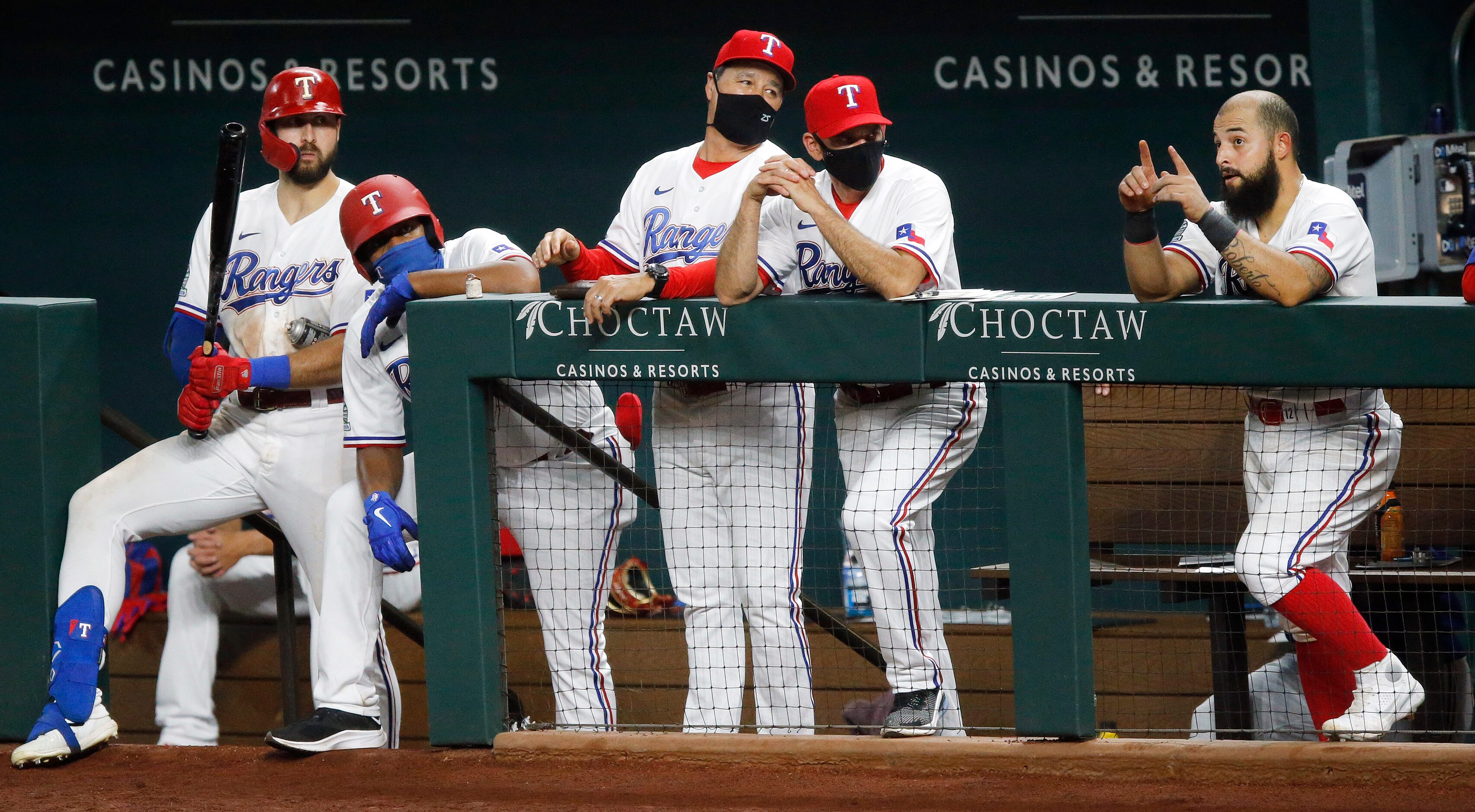 Texas Rangers manager Chris Woodward (second from right) and bench coach Dave Wakamatsu...