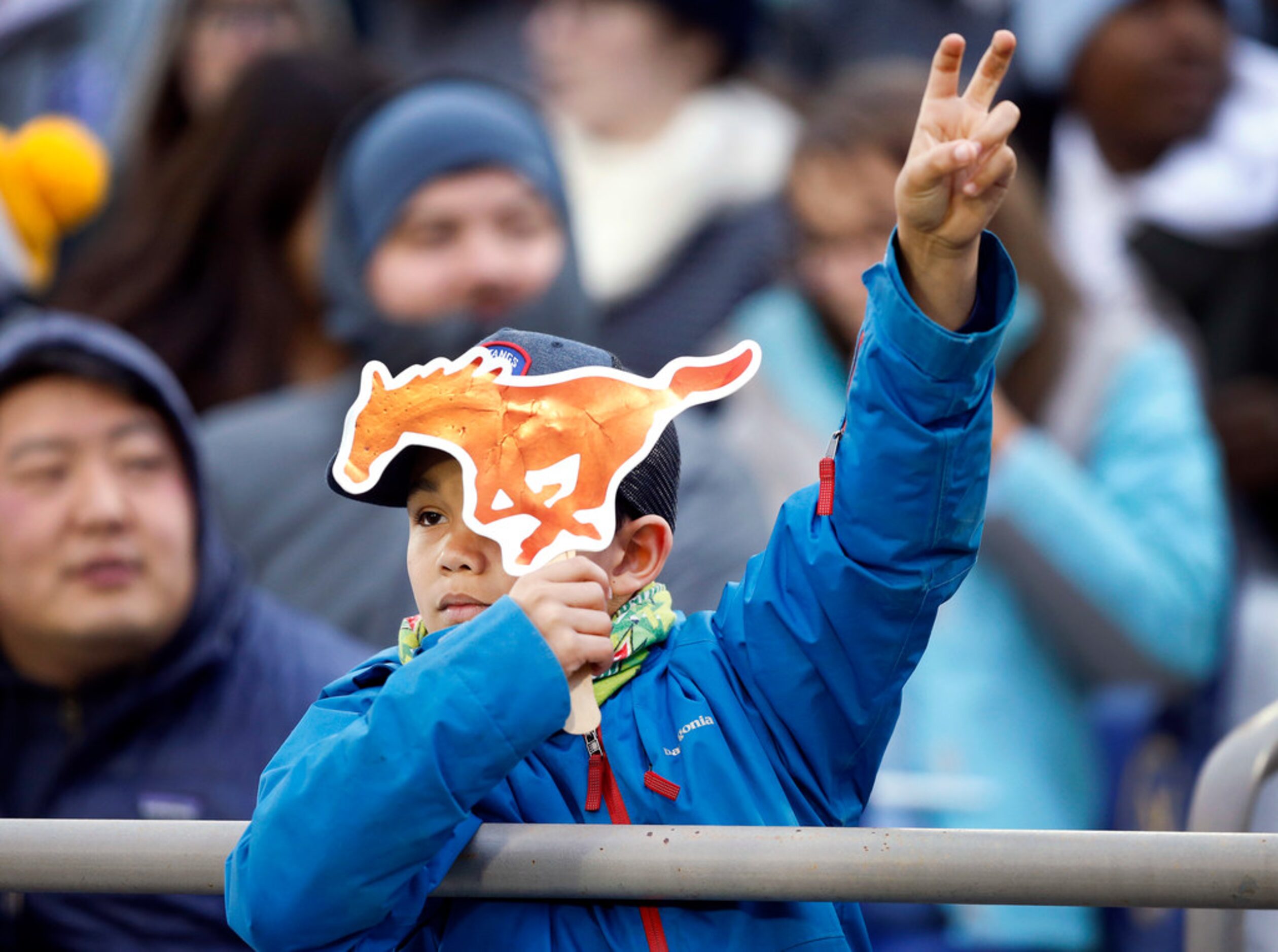 A young Southern Methodist Mustangs fan watches his team face the Navy Midshipmen at...