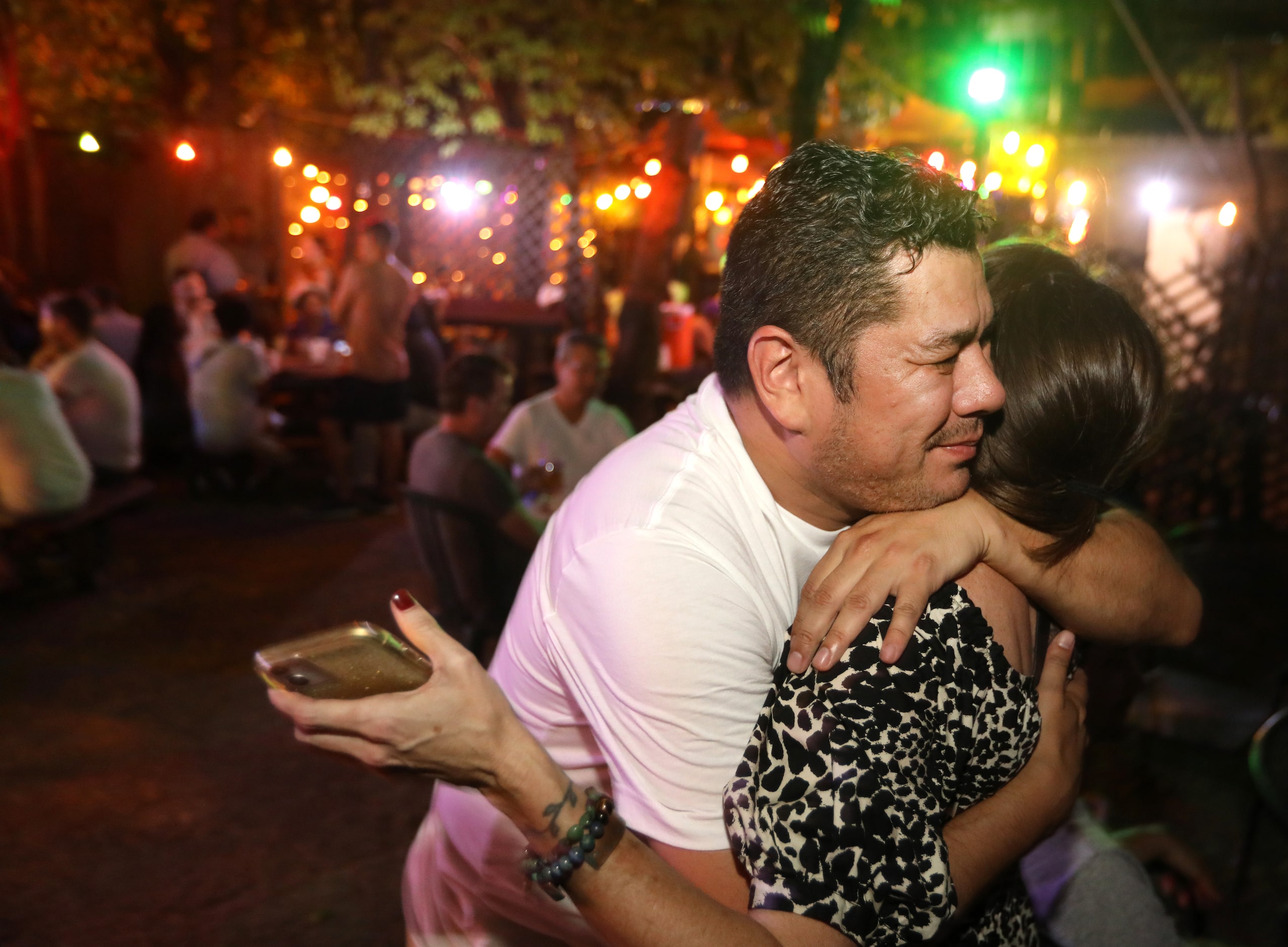 David Olarte, left, and Molly Tracy hug as they enjoy one last evening at the Grapevine Bar...