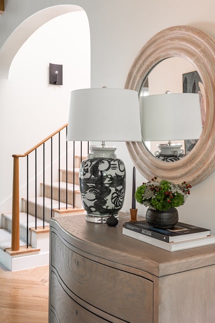 Wood ches, wood-framed circular mirror and lamp near staircase