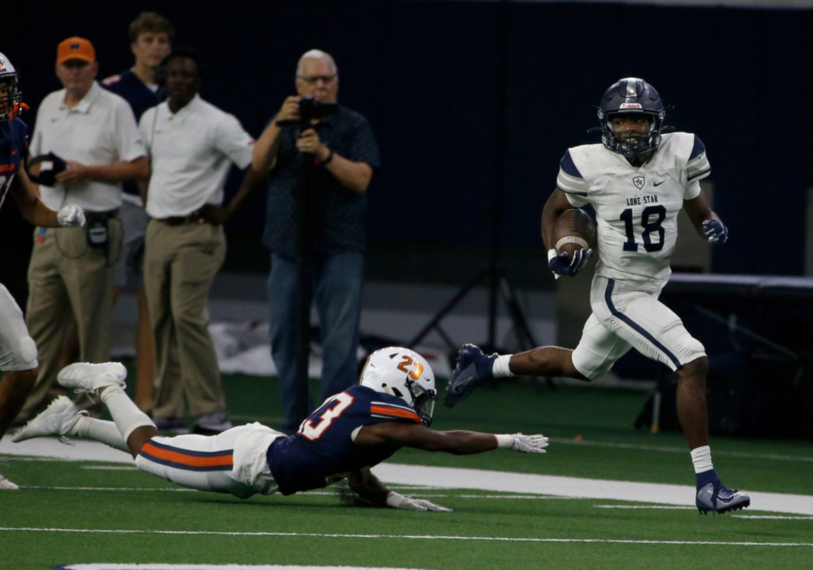 Frisco Lone Star's Marvin Mims (18) runs away from Frisco Wakeland's Quincy Leslie (23) to...