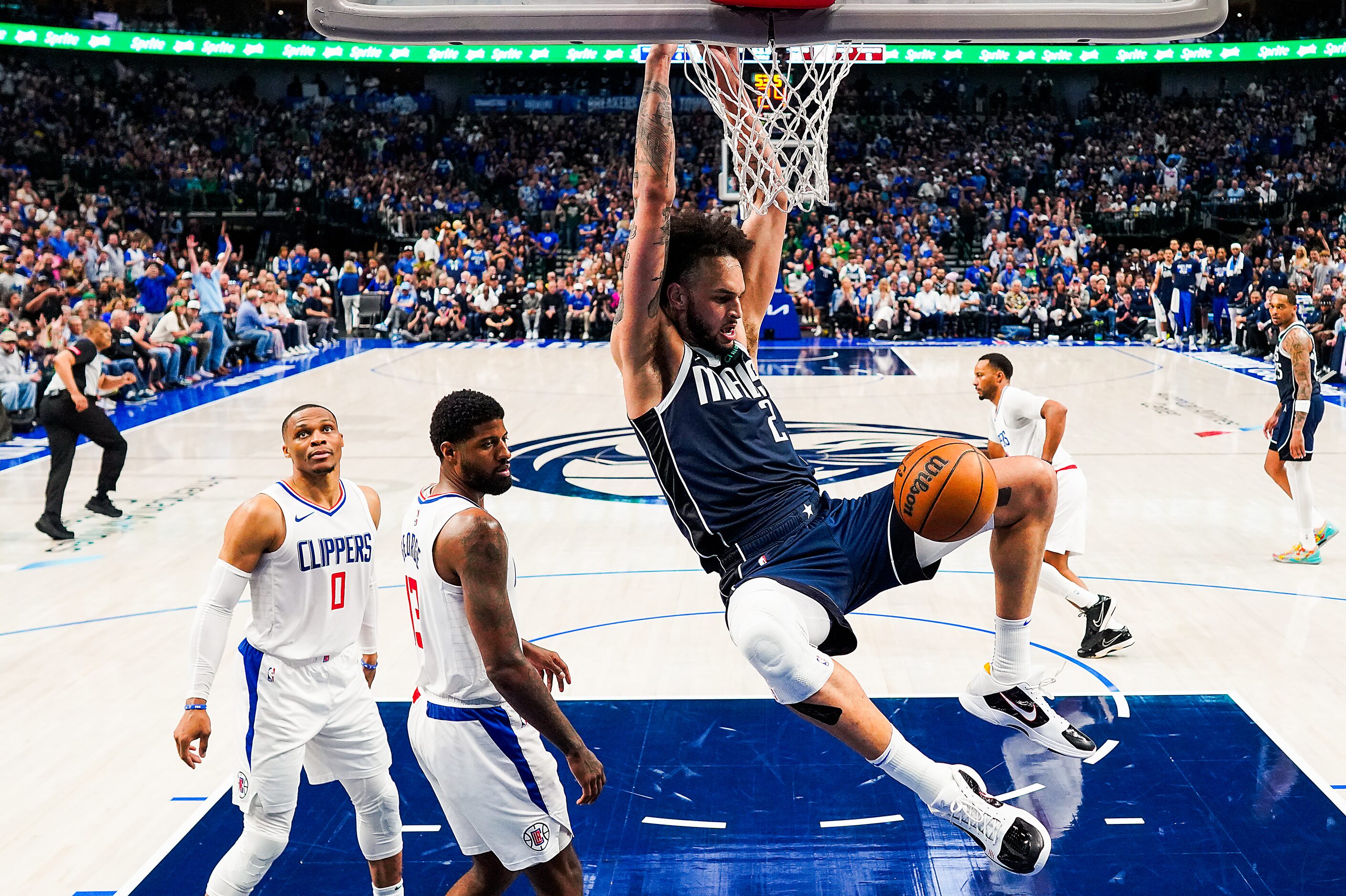 Dallas Mavericks center Dereck Lively II (2) hangs on the rim as he dunks the ball past LA...