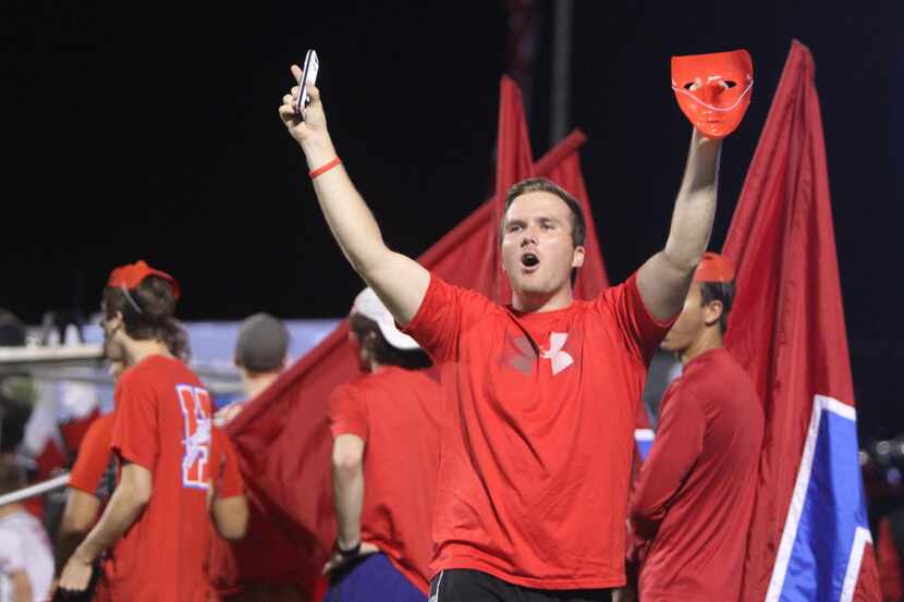 A Midlothian Heritage fan rouses the Jaguars fans in the stands during the second quarter of...