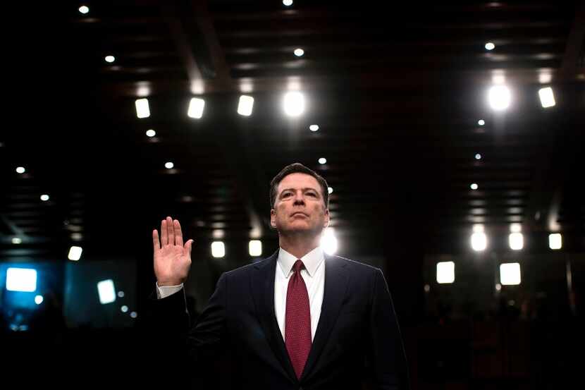 Ousted FBI director James Comey is sworn in during a hearing before the Senate Select...