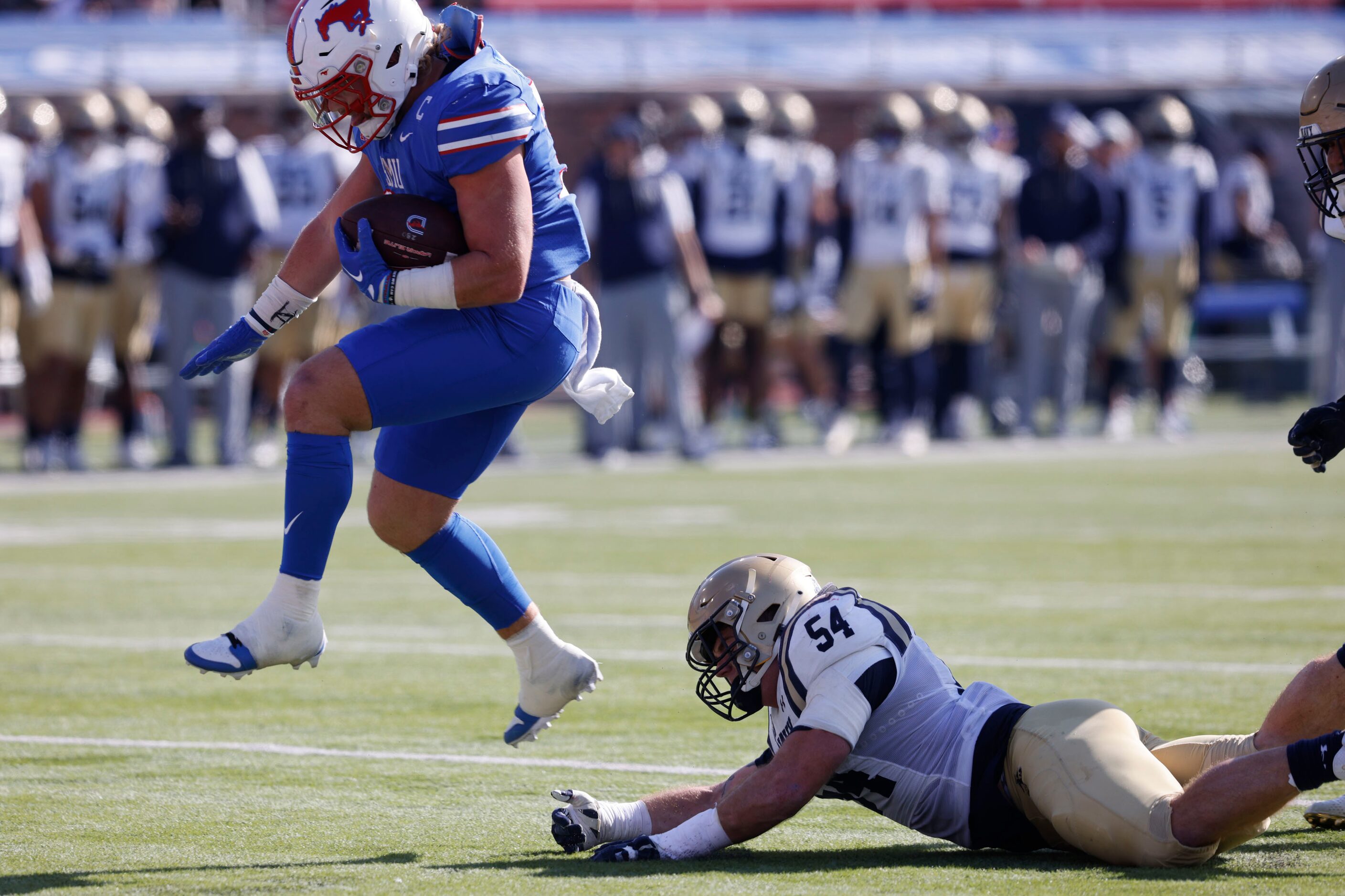 SMU running back Tyler Lavine (31) scores a touchdown over Navy linebacker Will Harbour (54)...