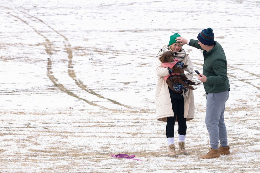 Greg Douglas adjusts the beanie of Sara Douglas as she prepares to take a photo with their...