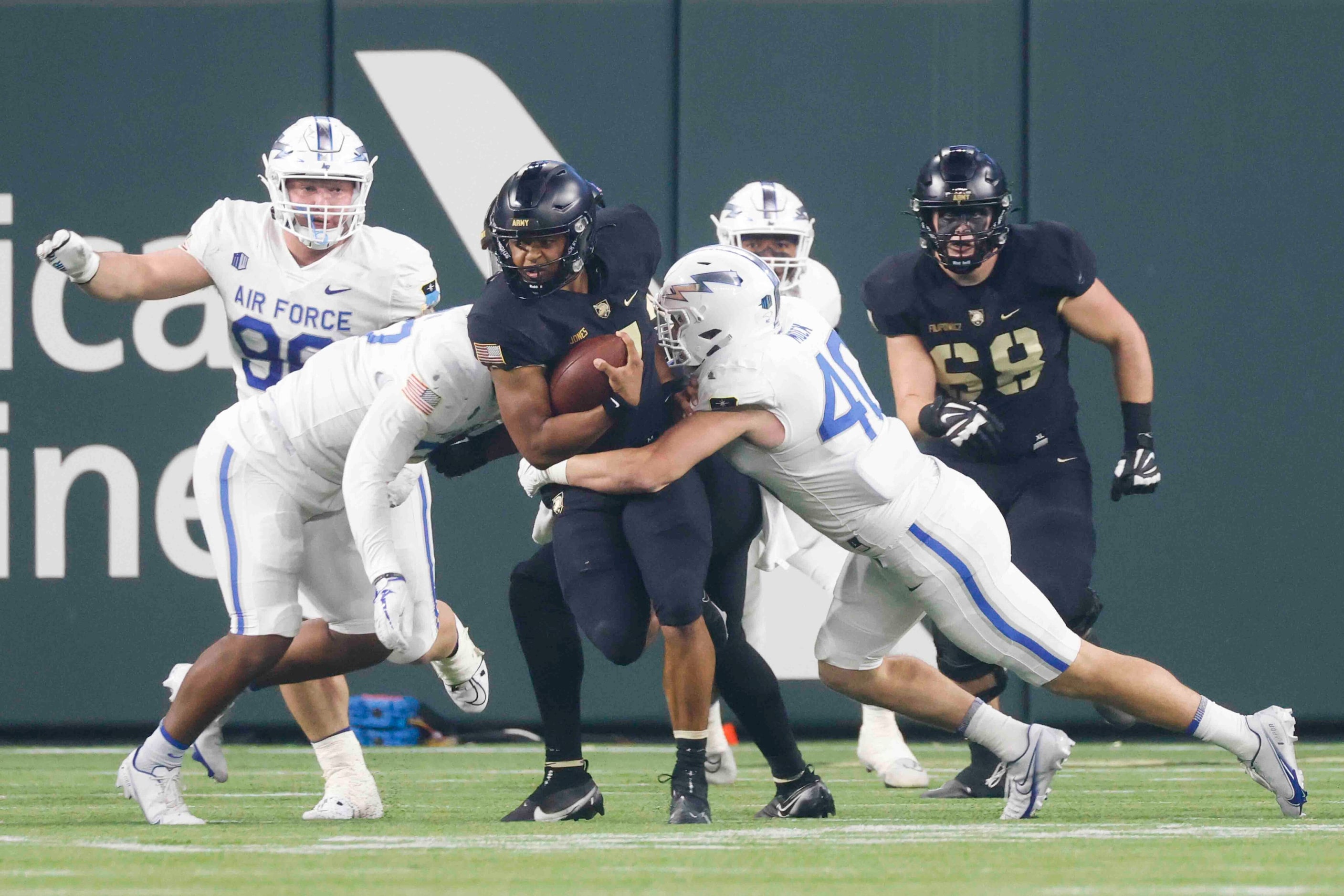 Army quarterback Jemel Jones (7), center, runs past Air Force linebacker Alec Mock (40)...