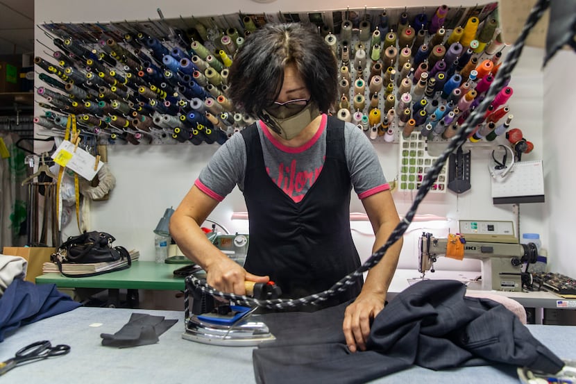 Yoon Seok presses a pair of pants for alterations at Preston Royal Cleaners and Lucy's...