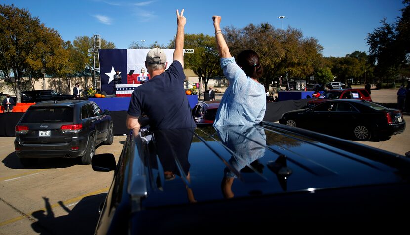 Through the sunroof of their vehicle, Biden campaign staffer Teri Ervin (right) and her...