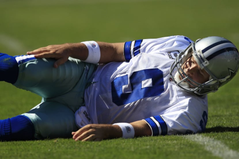 Dallas Cowboys quarterback Tony Romo (9) lays on the ground after being hit by San Francisco...