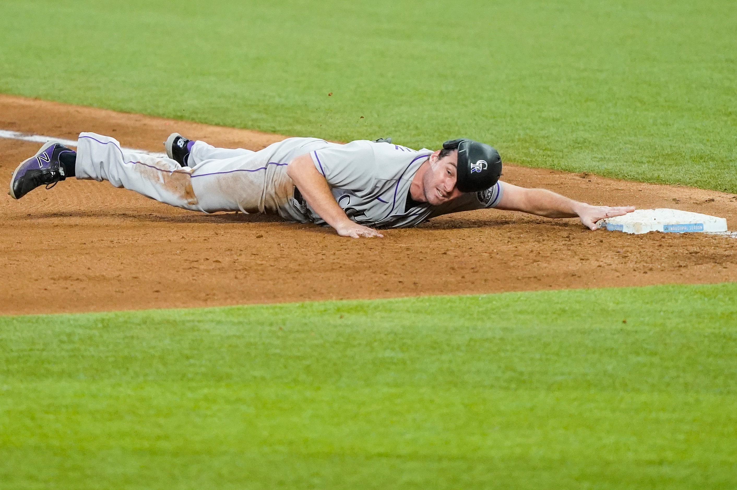 Colorado Rockies first baseman Daniel Murphy gets back to first past Texas Rangers first...