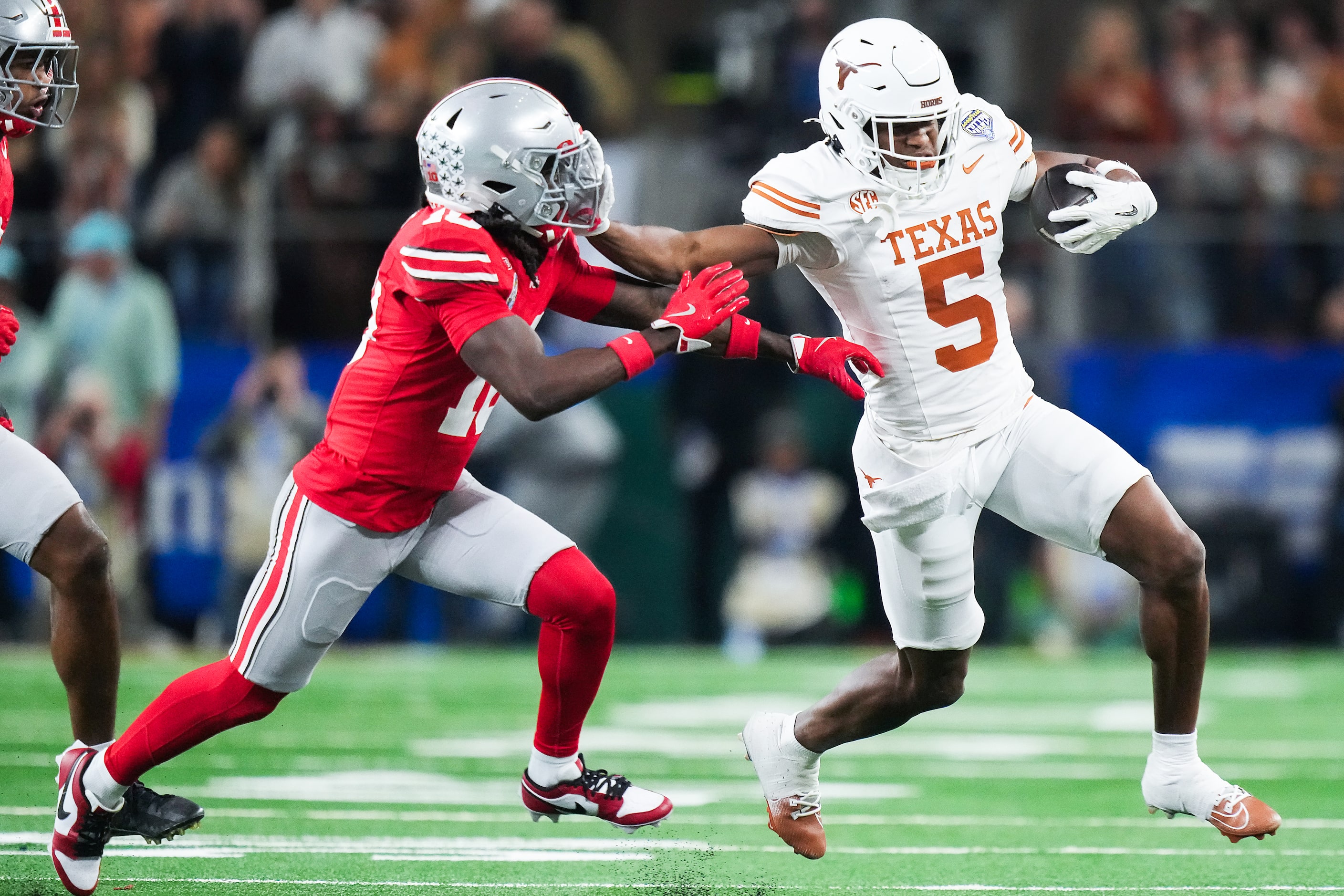 Texas wide receiver Ryan Wingo (5) pushes away from Ohio State cornerback Denzel Burke (10)...