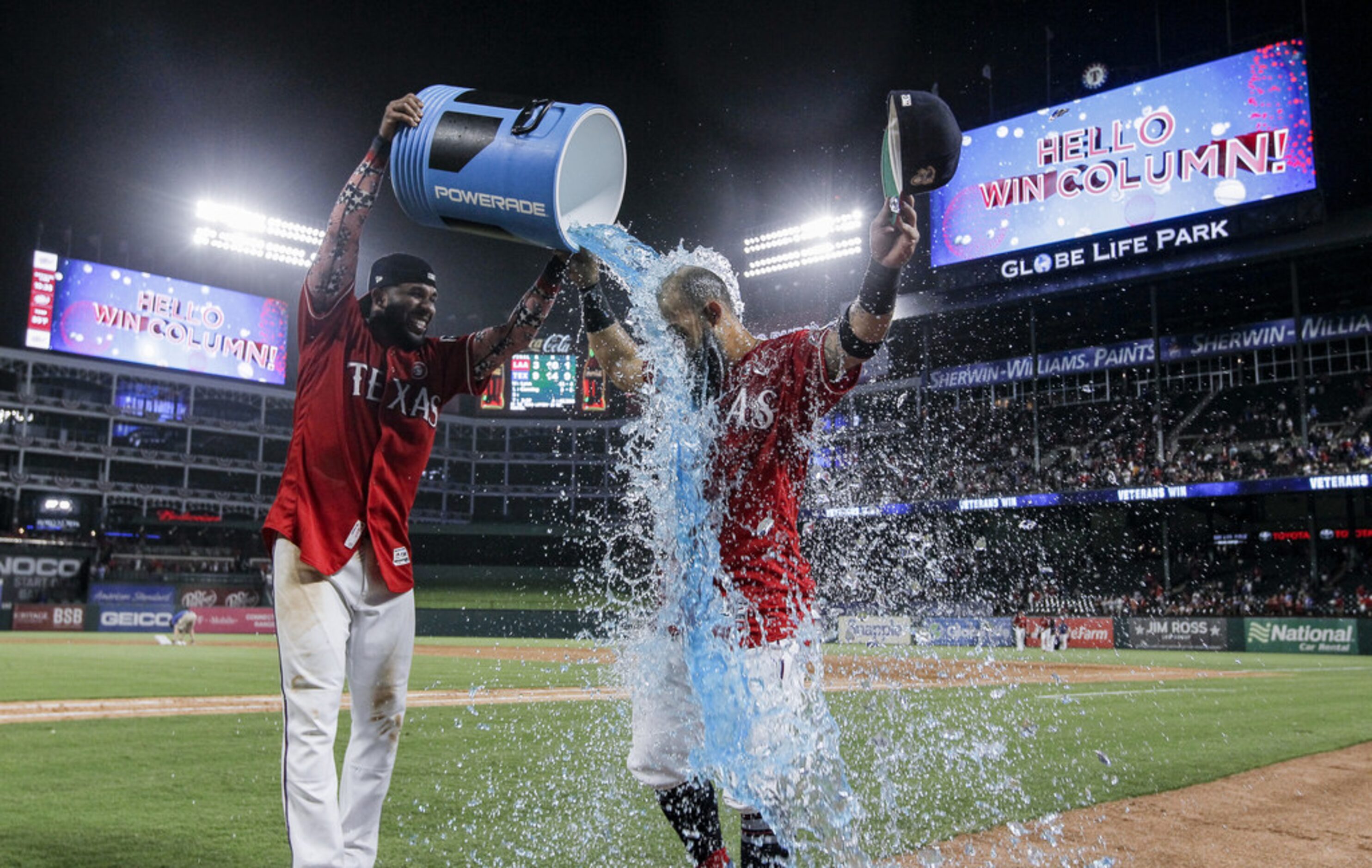 ARLINGTON, TX - JULY 4: Elvis Andrus #1 of the Texas Rangers, left, dumps a cooler of sports...