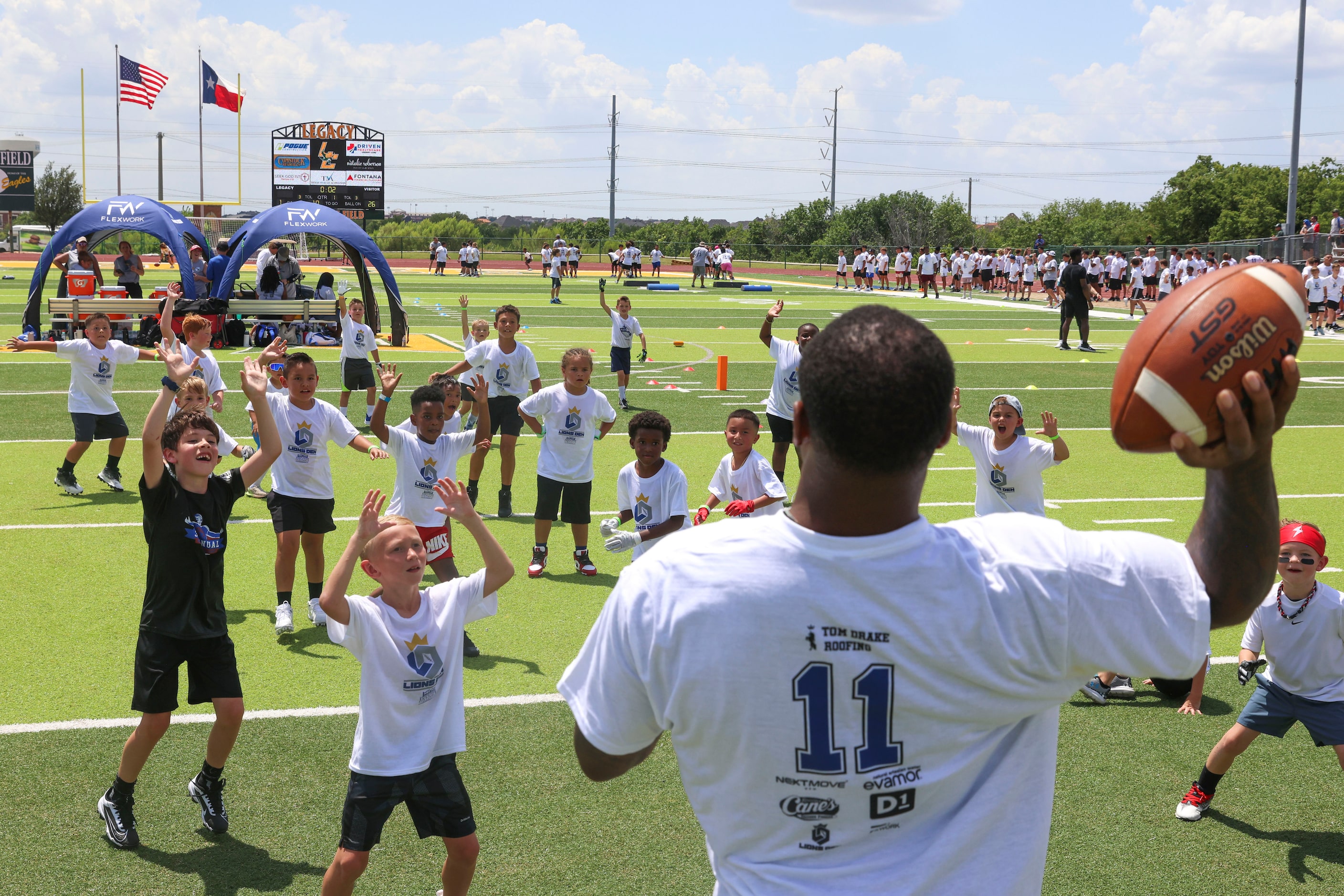 Dallas Cowboys linebacker Micah Parsons looks to throw the ball as he interacts with young...