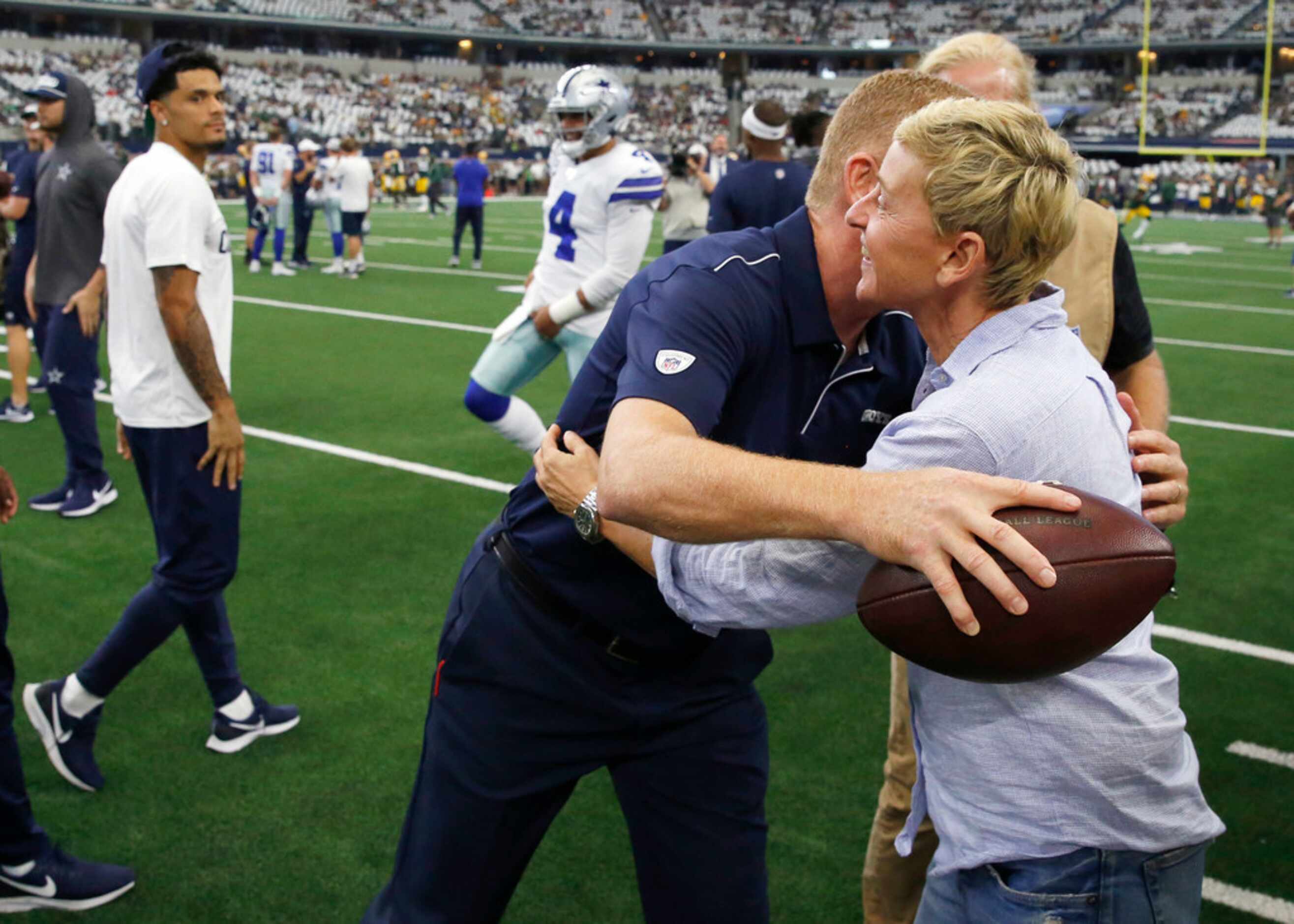 Dallas Cowboys head coach Jason Garrett hugs Ellen DeGeneres before a game against the Green...