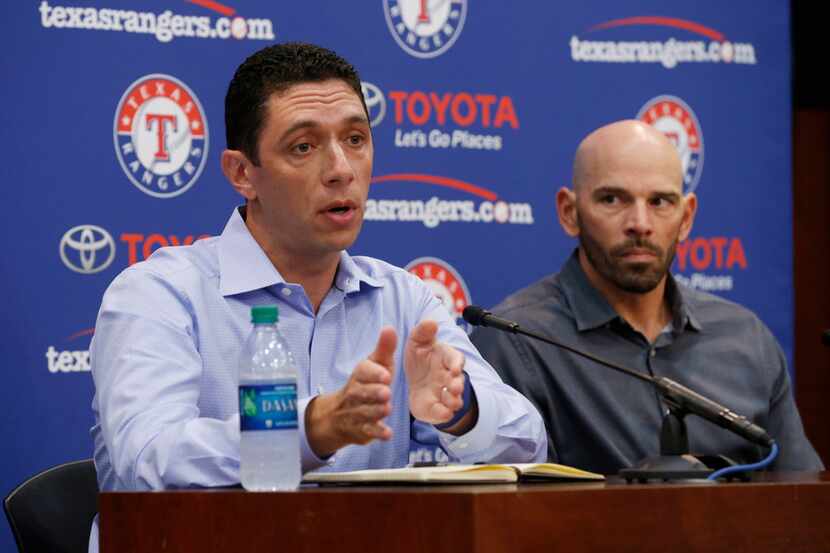 FILE — Texas Rangers general manager Jon Daniels and manager Chris Woodward talk to the...