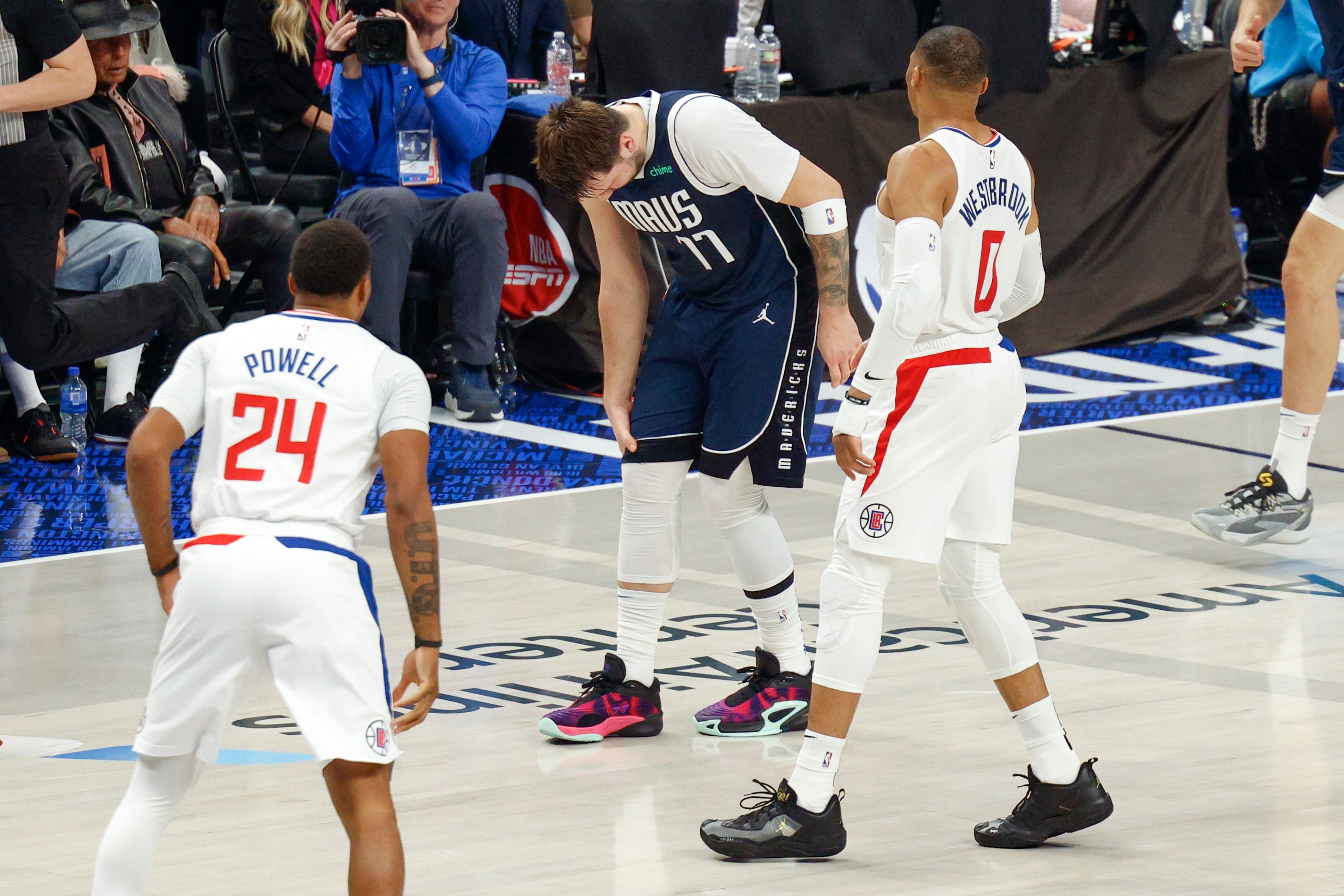 Dallas Mavericks guard Luka Doncic (77) grabs his knee after colliding with LA Clippers...