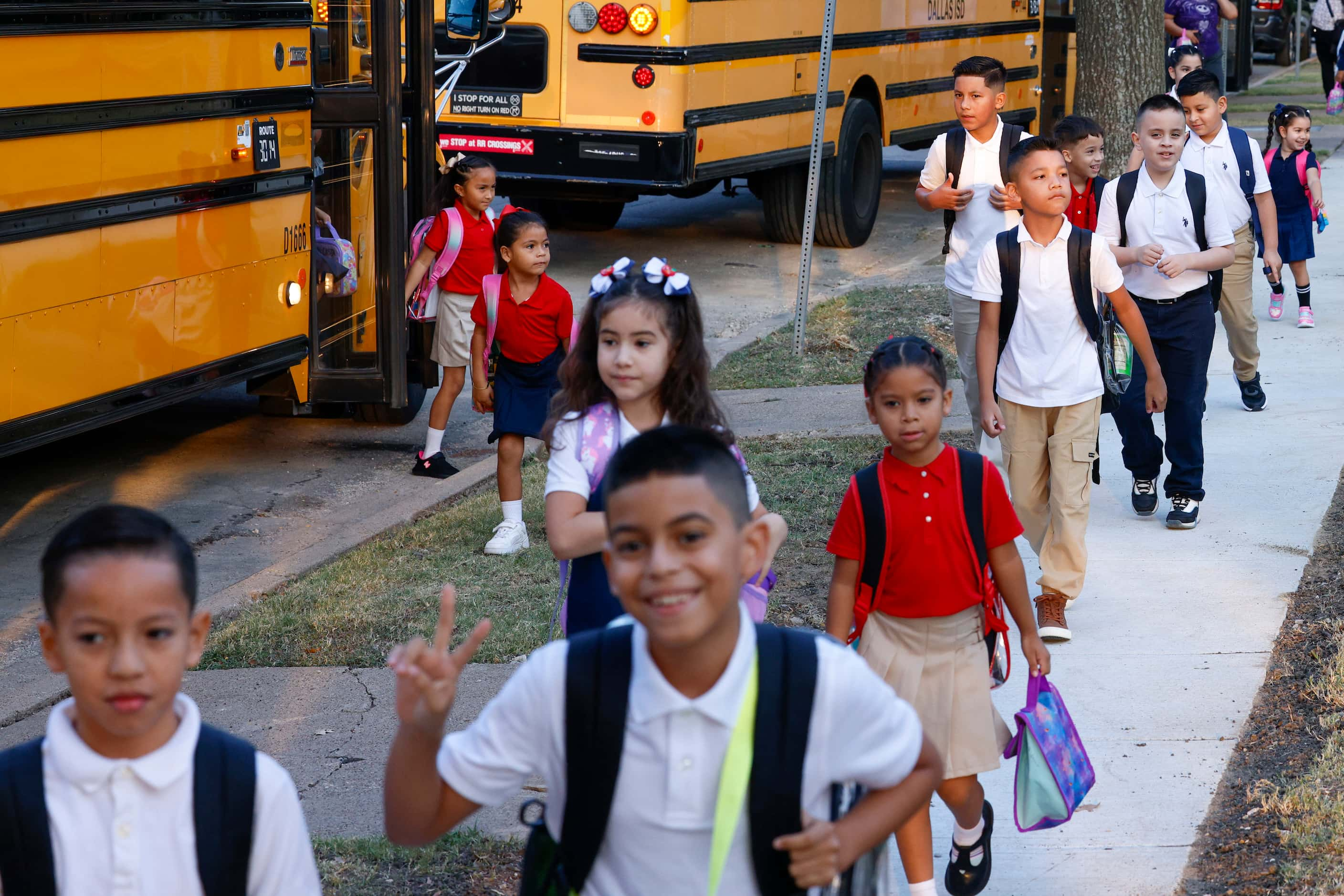 Students exit buses and walk to John J. Pershing Elementary School for the first day of...