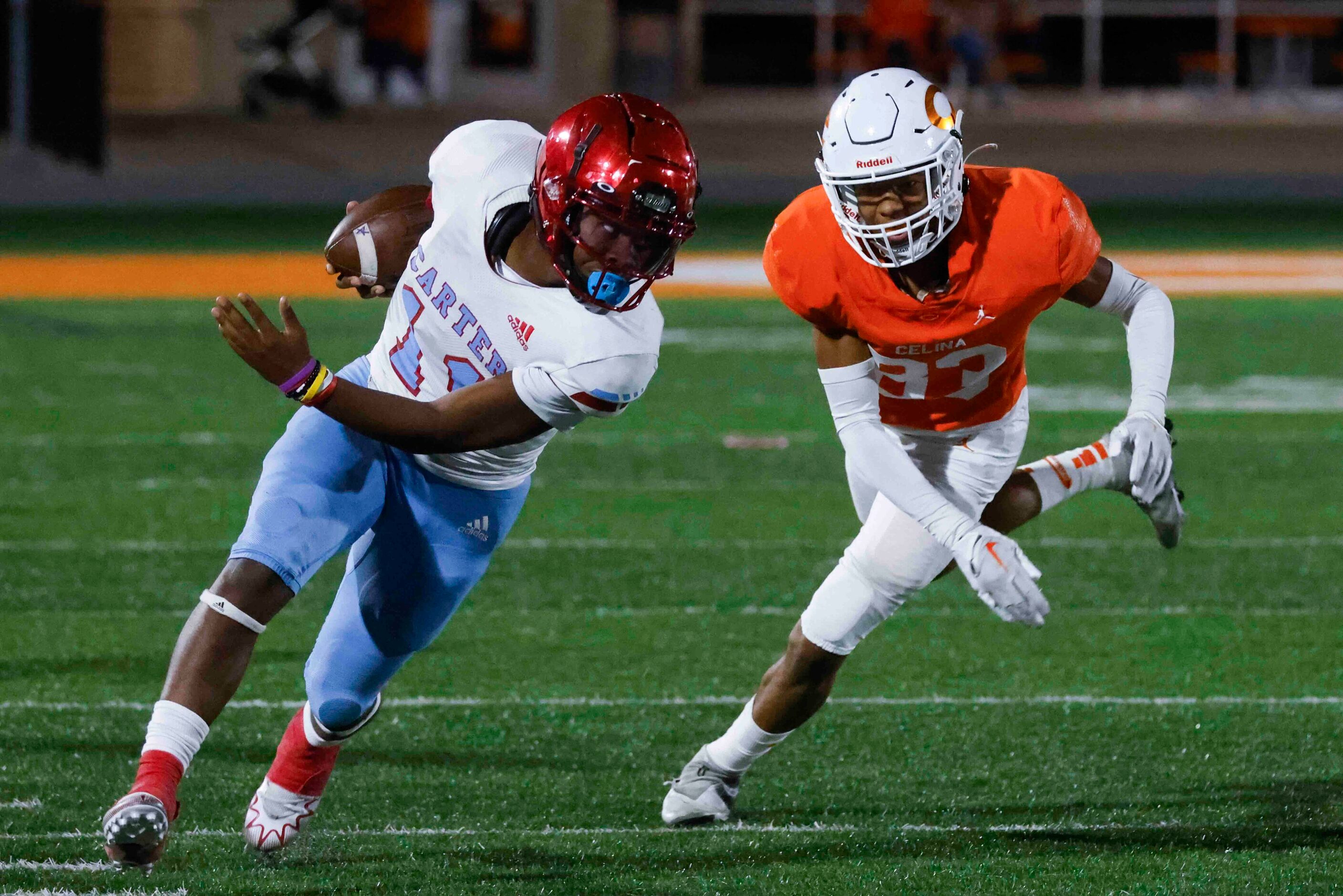 David W. Carter High School’s Kaeden Landry (24), left, runs past Celina High School’s Kaleb...