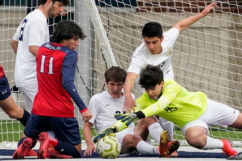 Jesuit goalkeeper Cole Hines (55) makes a save in front of McKinney Boyd forward Jonathan...