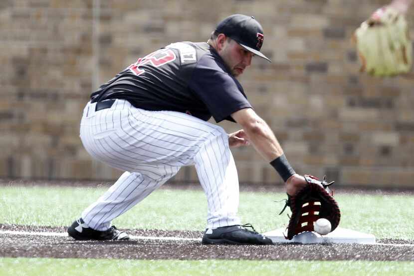 Texas Tech's Eric Gutierrez catches the ball at first base to tag out the batter at an NCAA...
