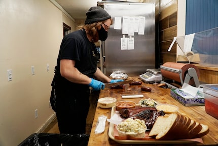 Goldee's Barbecue co-owner Lane Milne slices meat at the restaurant in Fort Worth.