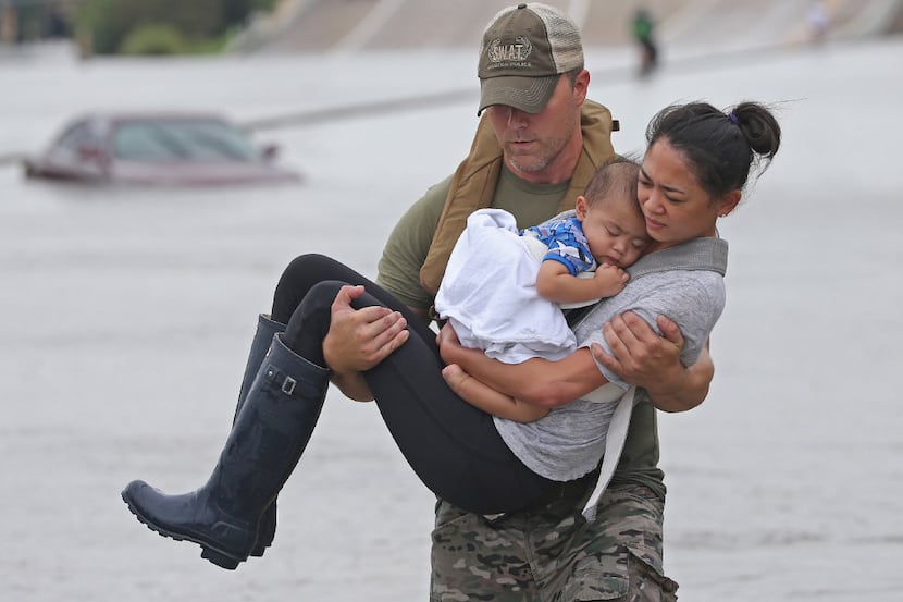 Houston SWAT officer Daryl Hudeck carried Catherine Pham and her 13-month-old son, Aidan, to...