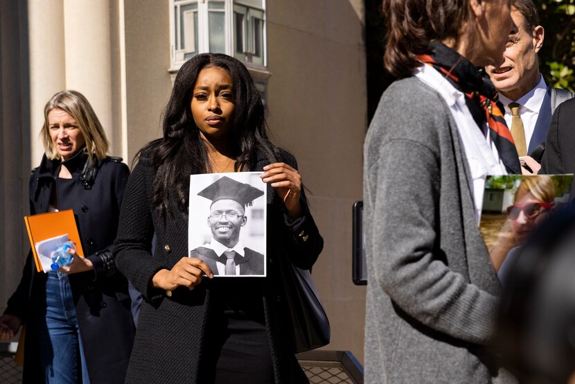 Zipporah Muthoni Kuria holds a photo of her father, Joseph Kuria Waithaka, after she and...