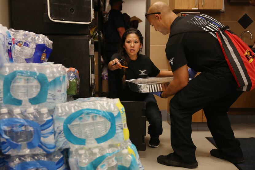 Jennifer Do directs Houston police Officer Mike Enriquez as she helps to manage the kitchen...