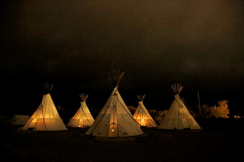 Teepees are illuminated by interior fire pits  before dawn at El Cosmico. (Guy...