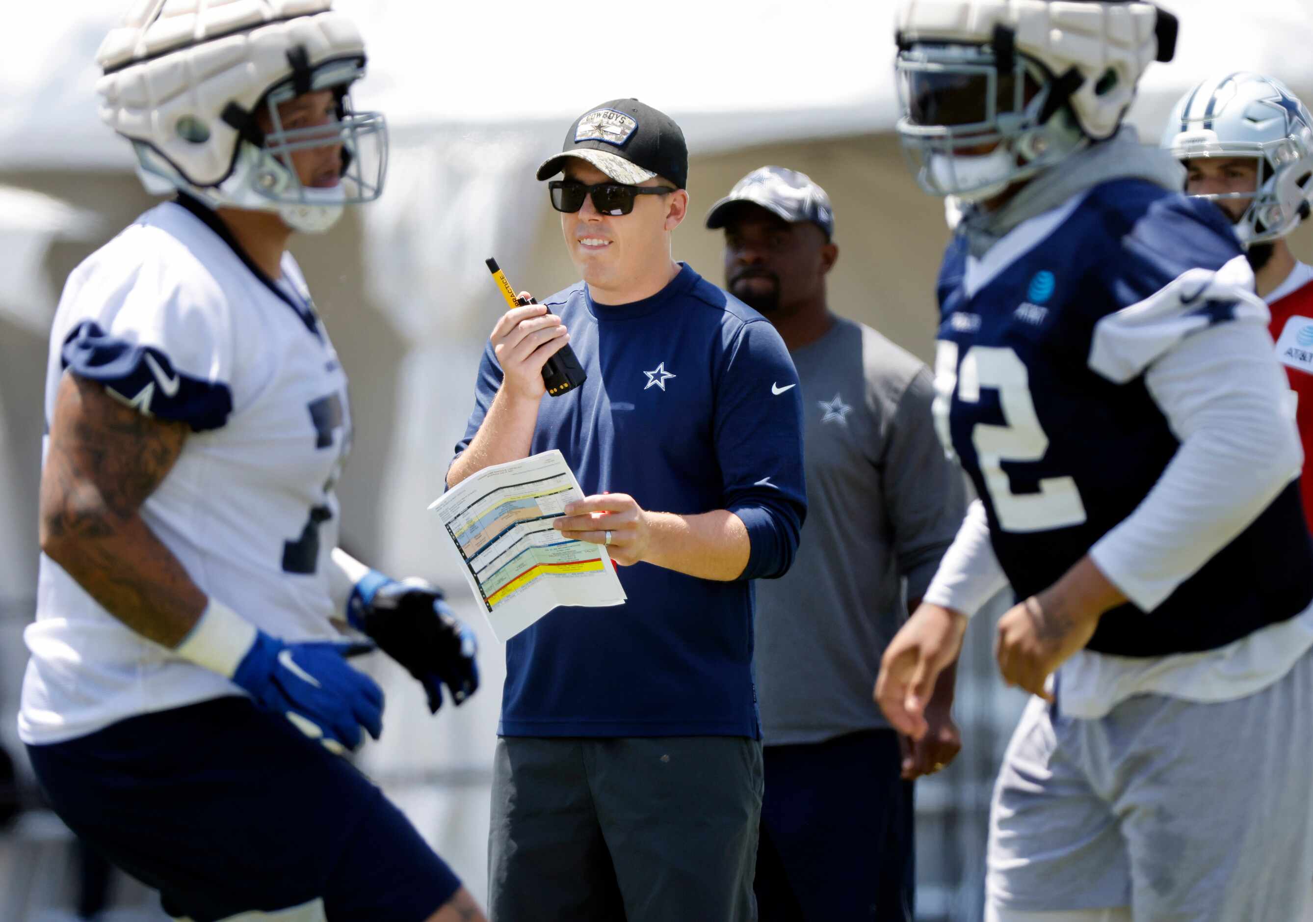 Dallas Cowboys offensive coordinator Kellen Moore keeps tabs on a two-minute drill they were...