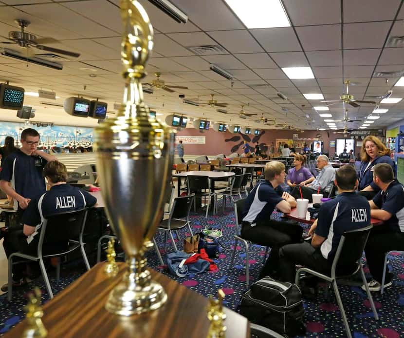 
The Allen High School bowling team takes a break next to its first-place state trophy at...