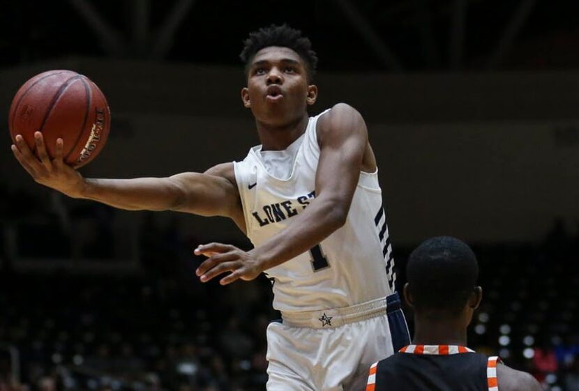 Frisco Lone Star's Julian Larry (1) goes up for a shot over Lancaster's Devon Miller (11)...